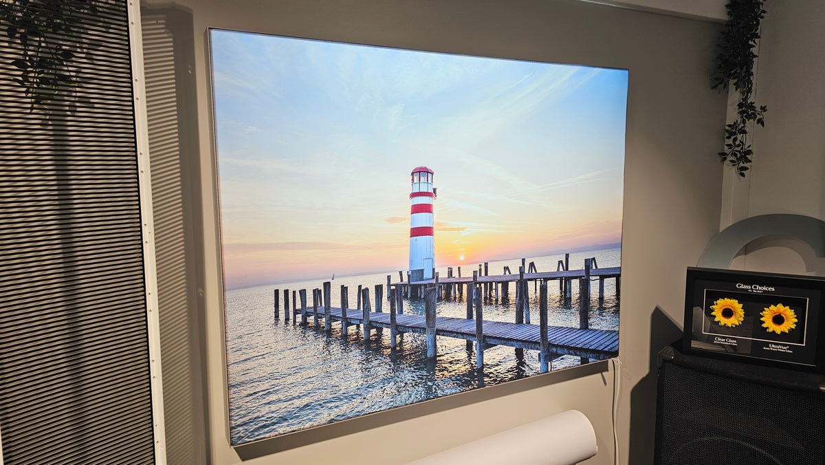 Originalfoto: eingeschalteter Textil-Leuchtrahmen mit Leuchtturm-Motiv im Schauraum.